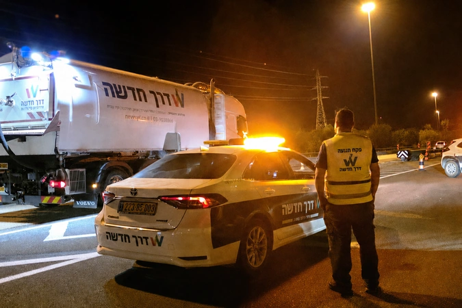 עבודת לילה להסרת סימוני כביש עם פקח תנועה